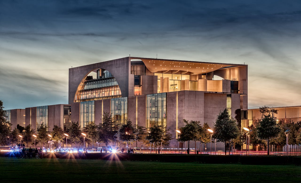 Panoramic view of the Berlin Federal Chancellery during twilight, showcasing modern architectural design.